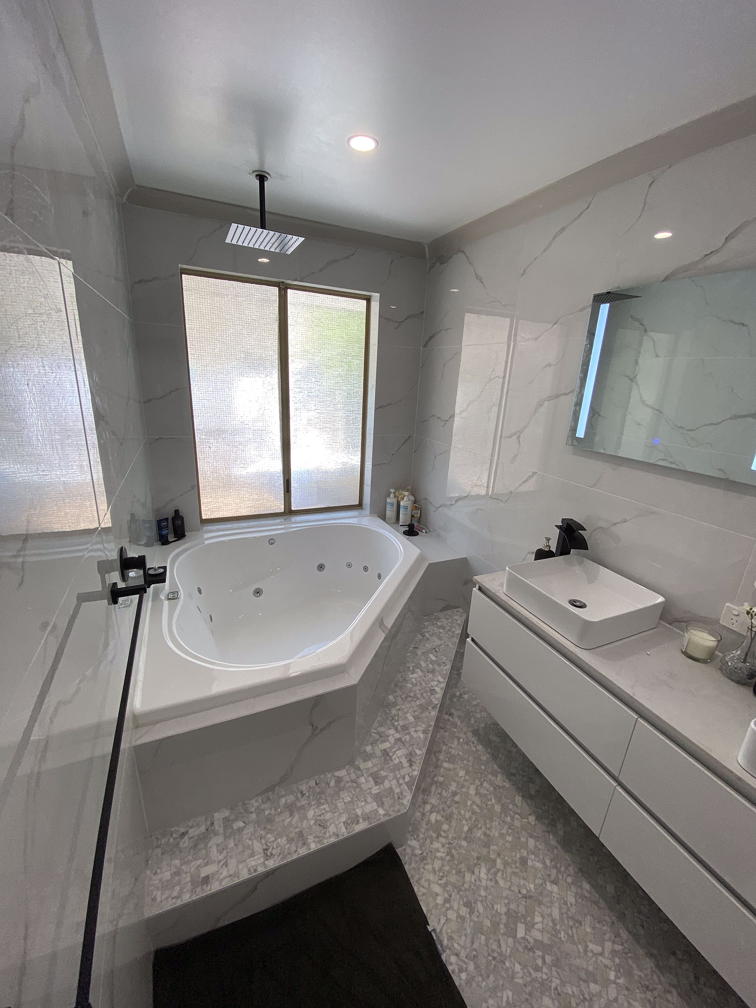 Spacious bathroom with bathtub, shower, and twin vanities.